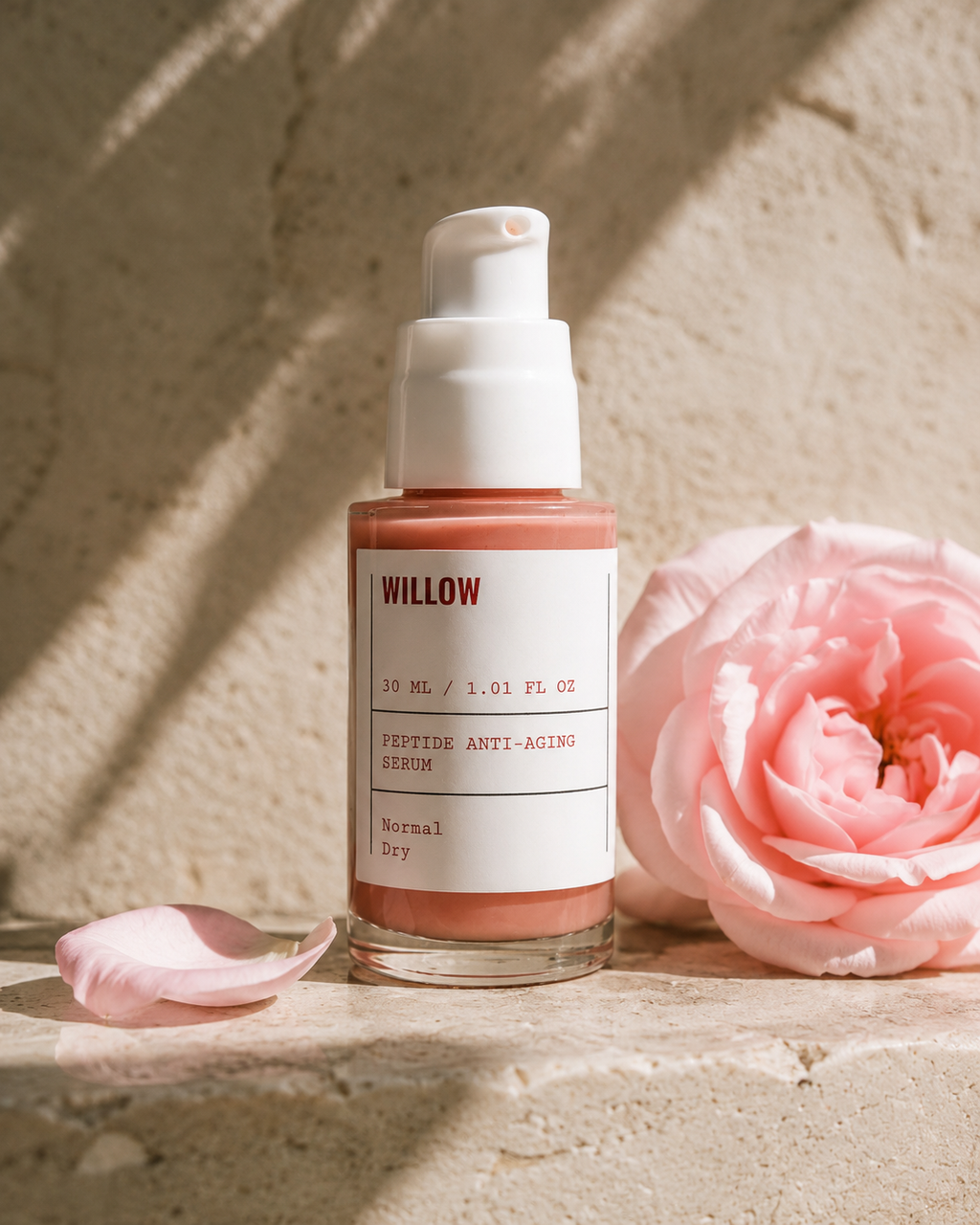 Willow Peptide Anti-Aging Serum with peptides for fine lines and wrinkles displayed beside a fresh pink rose in warm natural sunlight.